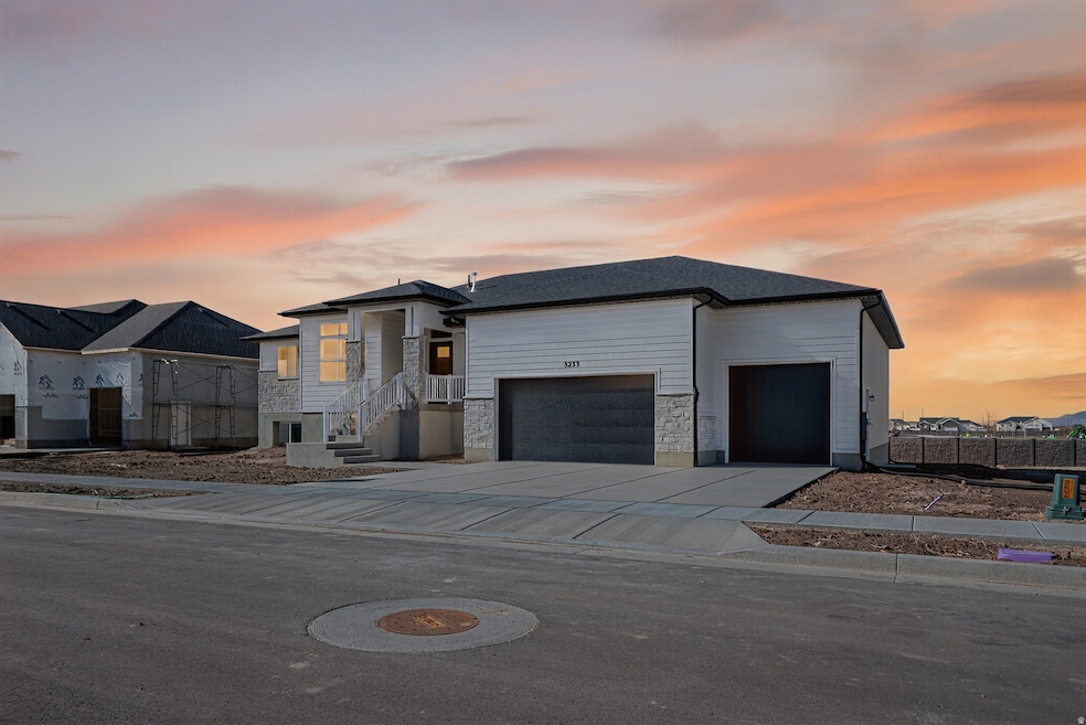 View of front of house with stone siding, concrete driveway, and an attached garage