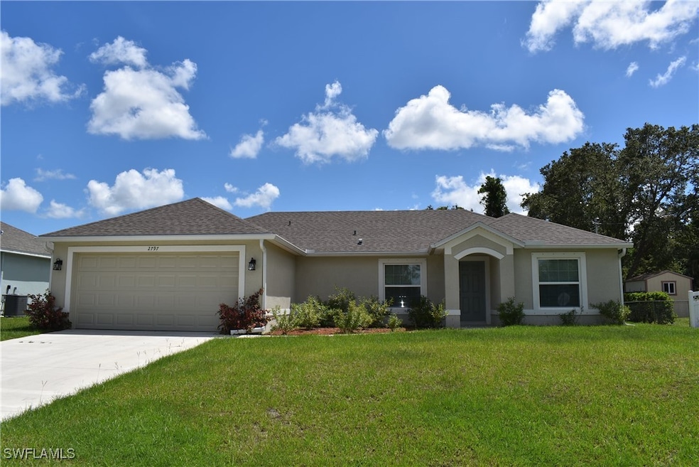 Ranch-style home featuring stucco siding, an attached garage, a front lawn, and driveway