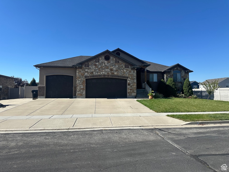 View of front of house with concrete driveway, a garage, and stone siding