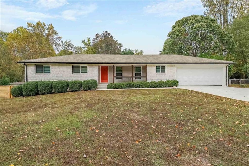 Ranch-style house featuring a garage, a front lawn