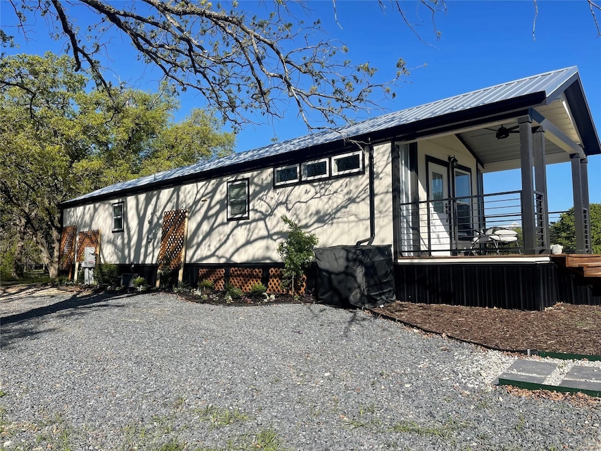 View of side of home featuring a metal roof and covered porch