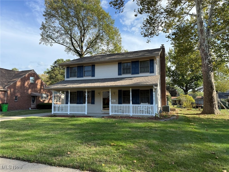 View of front of home featuring a porch, a front lawn, and a chimney