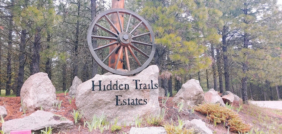 Community / neighborhood sign with a wooded view