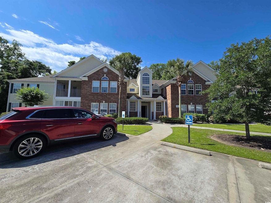 View of front of house with a front lawn, brick siding, and uncovered parking