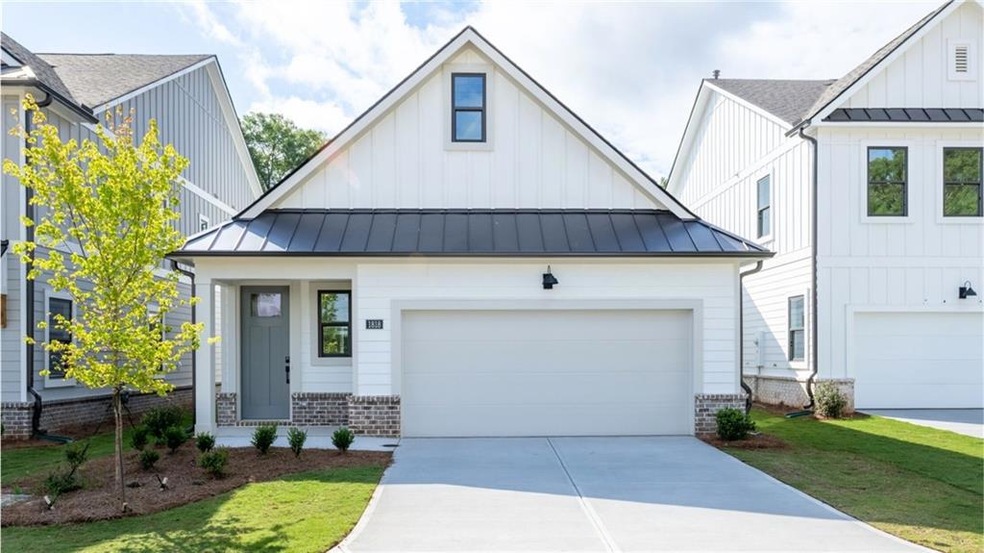 Modern farmhouse style home featuring a standing seam roof, board and batten siding, brick siding, driveway, and a garage
