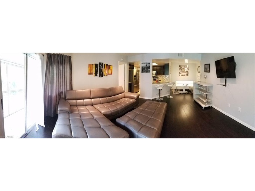 Remodeled living area with hardwood floors through