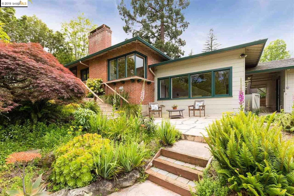 House partially sheltered from view by trees.  Mature Japanese maple.  Ext corner of LR & Family Rm