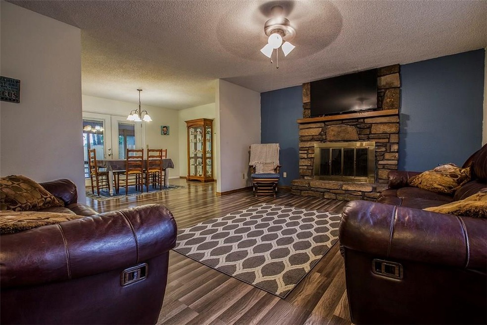 Walking in from the front door to the open living room with wood burning fire place and dining area with double doors leading to outside covered deck
