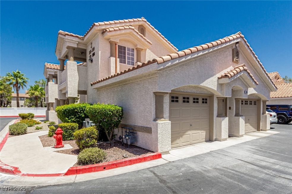 View of front facade with a tile roof, a garage, s