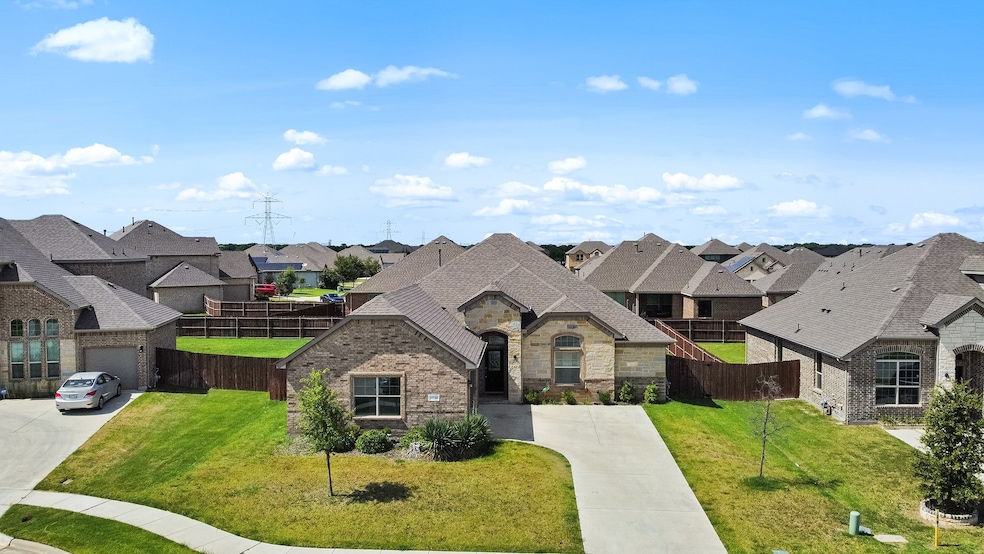 French provincial home with stone siding, a residential view, concrete driveway, and brick siding