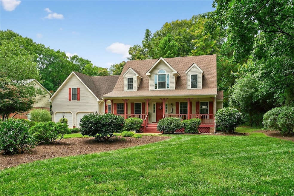 Cape cod-style house featuring a front lawn, a porch, roof with shingles, and a garage