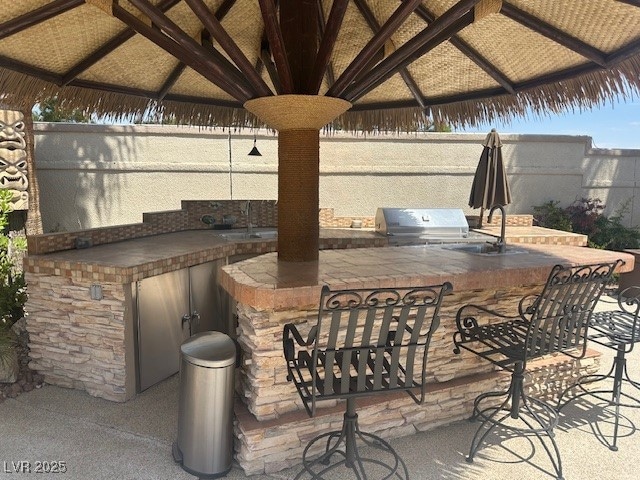 View of patio with outdoor wet bar, a gazebo, an o