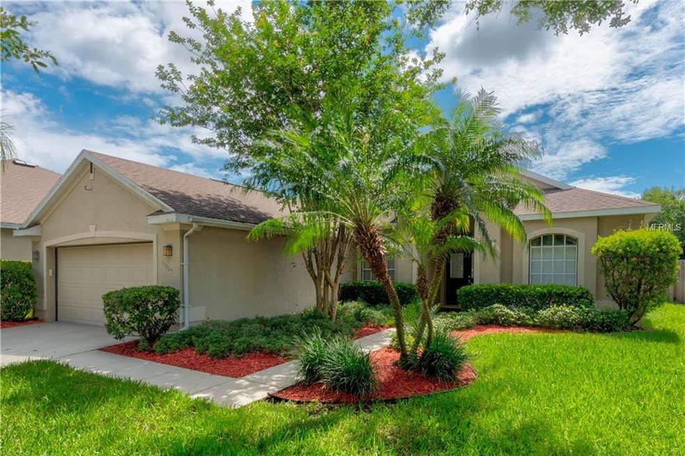 Charming curb appeal with tropical landscaping & a