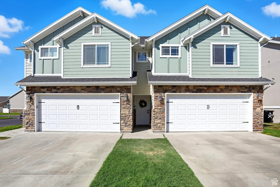 Craftsman inspired home featuring board and batten siding, stone siding, an attached garage, and concrete driveway