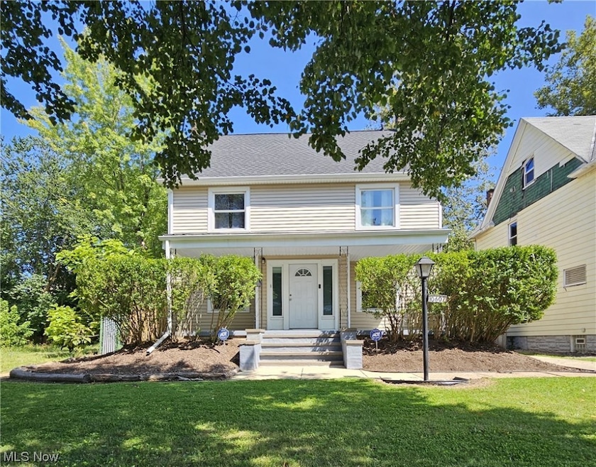 View of front of home featuring a porch, a front yard, and front door