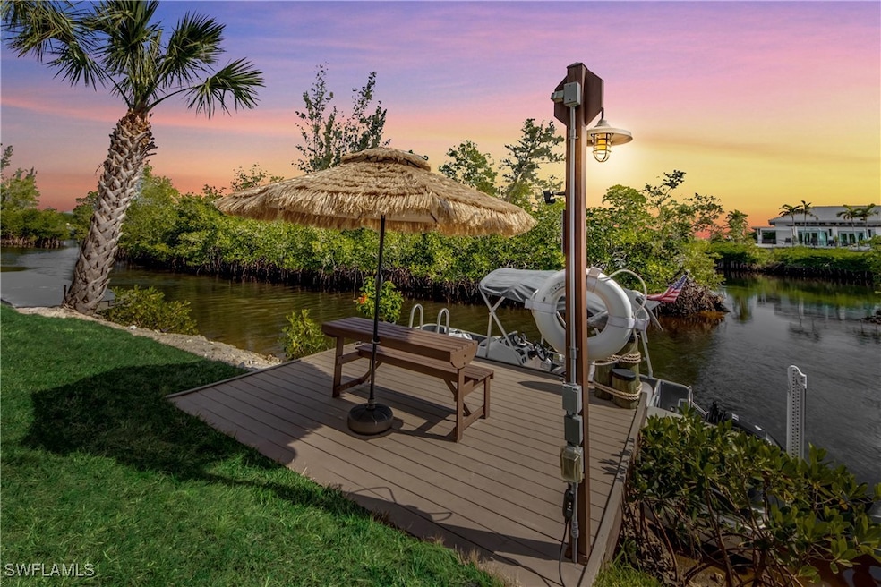 Dock area with a lawn and a water view