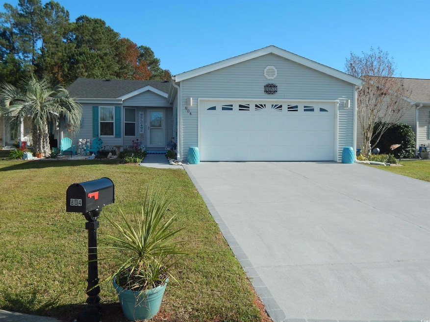 Ranch-style house featuring a front yard and a gar