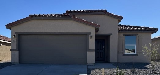 View of front of home with driveway, stucco siding