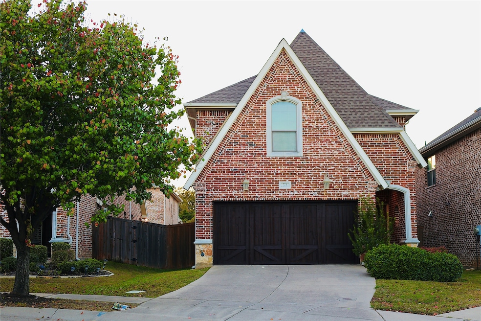View of front of home with a shingled roof, brick siding, a garage, and concrete driveway
