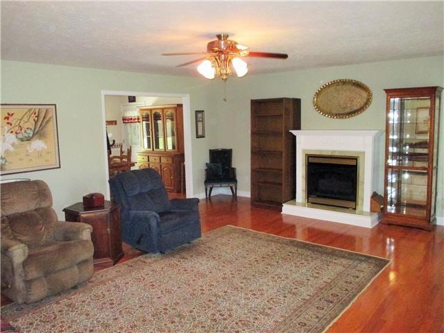 The inviting living room has new hardwood and paint (2013), a gas log fireplace, ceiling fan lighting and opens to the kitchen/dining area. The stairs to the second level are to the left of the front door. 