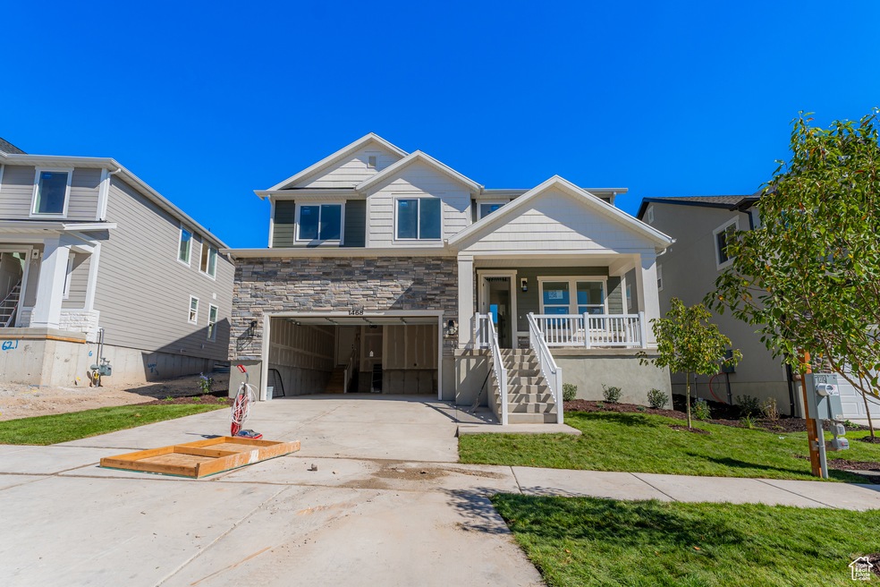View of front of house featuring concrete driveway, stairway, a front lawn, an attached garage, and a porch