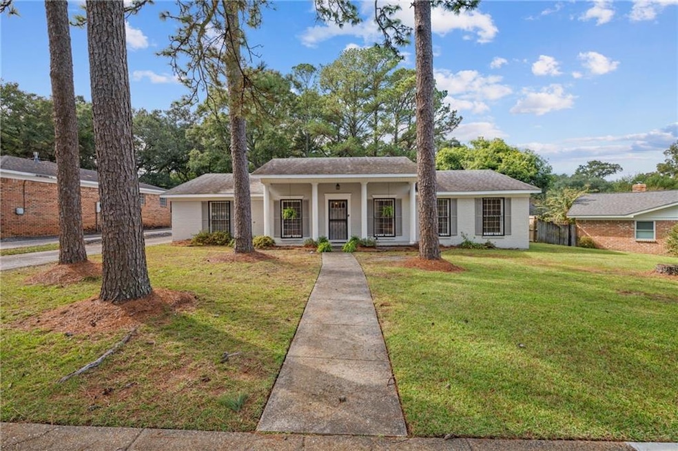View of front of home with a porch, brick siding, and roof with shingles