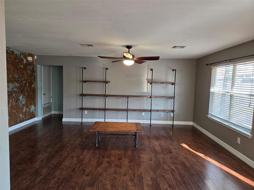 Unfurnished living room with wood finished floors and a ceiling fan