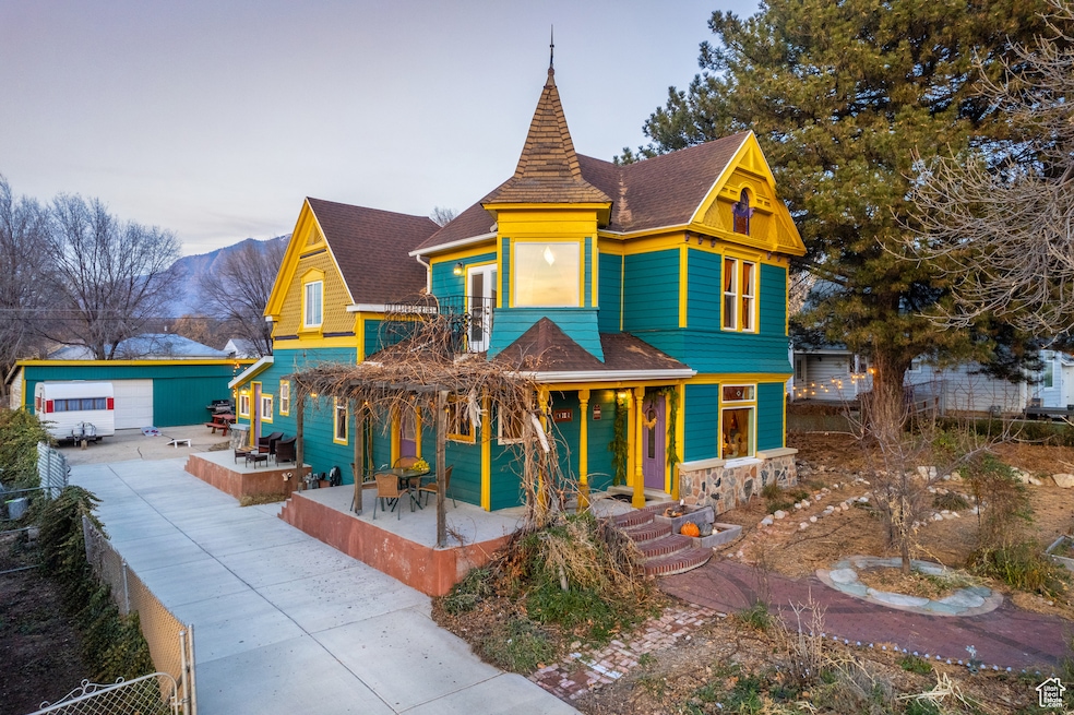 Victorian home with a shingled roof, a porch, a mountain view, and stone siding