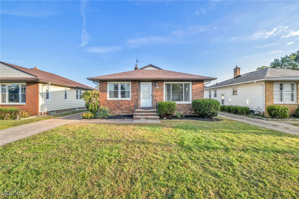Bungalow-style house featuring brick siding and a front lawn