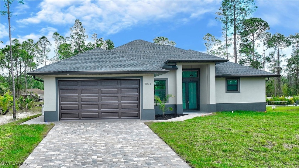 View of front of home with a garage and a front ya