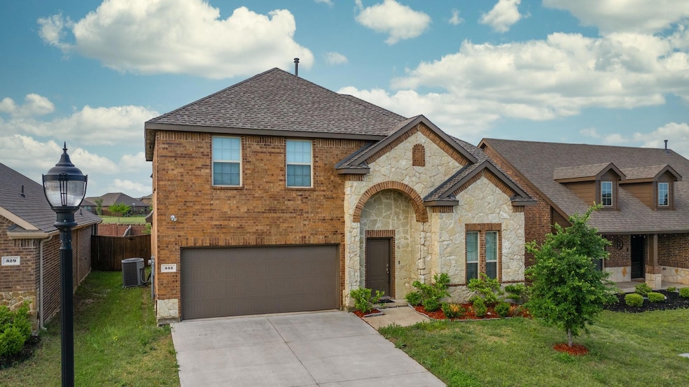 View of front of house with a front yard, a garage, and central AC