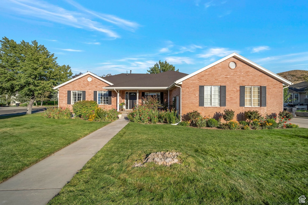 Single story home with a front yard, brick siding, and covered porch