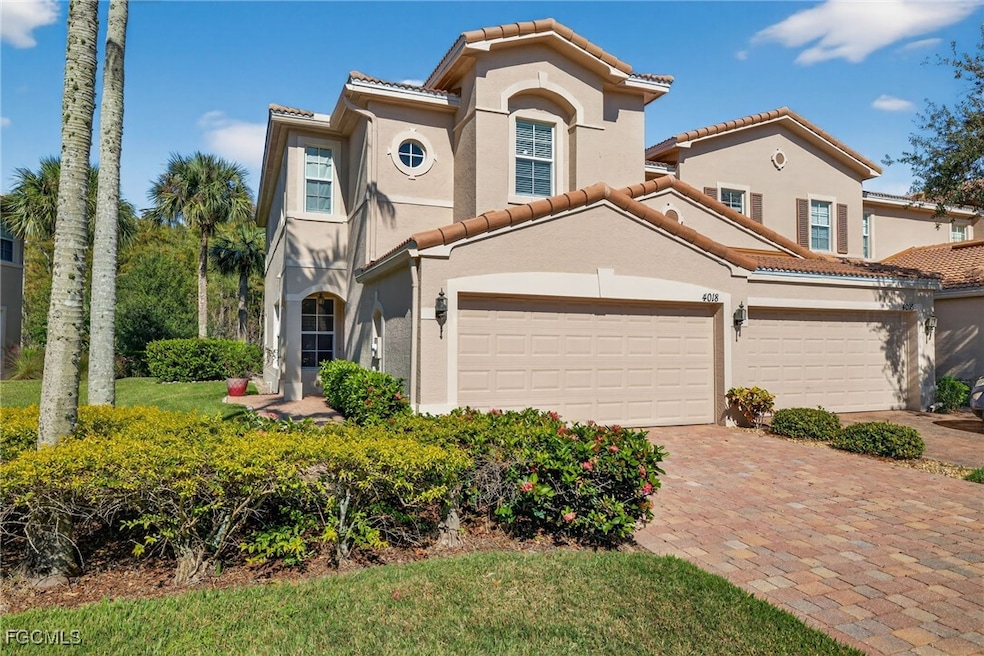 Mediterranean / spanish home featuring a tiled roof, stucco siding, and decorative driveway