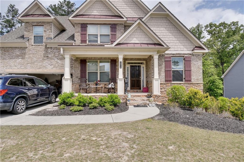 Craftsman-style home featuring covered porch and a front yard