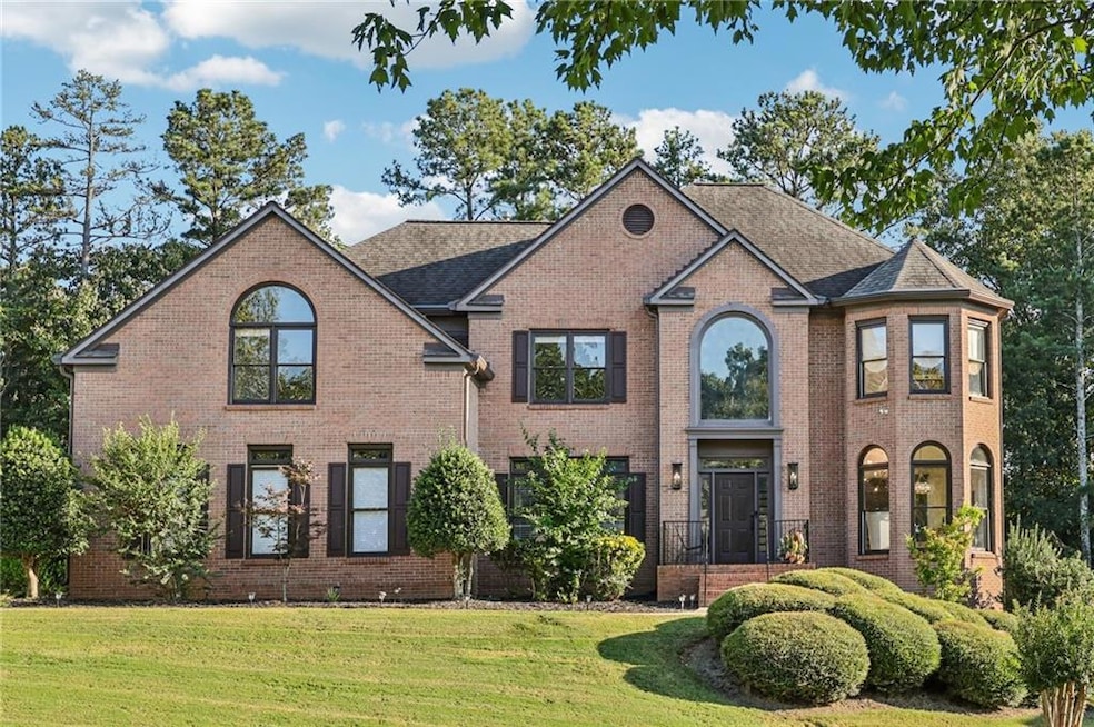 View of front of home with brick siding and a front lawn