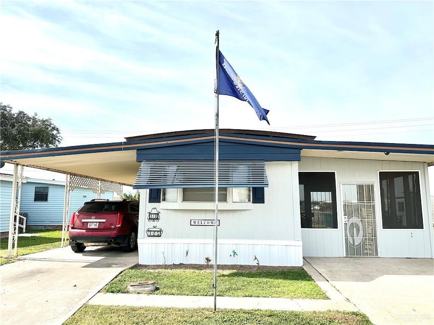 Manufactured / mobile home with a front yard and a carport