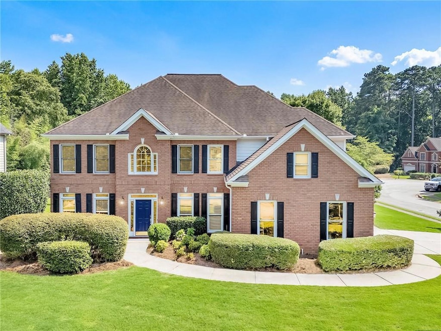 Colonial inspired home featuring a front lawn, brick siding, and a shingled roof