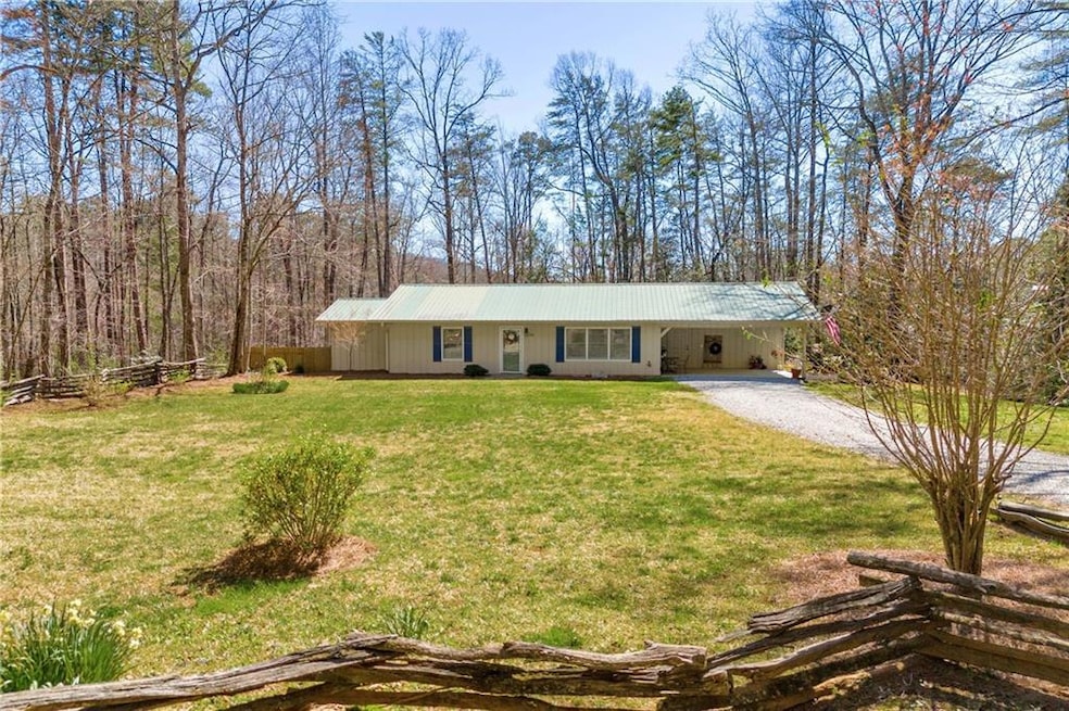 Ranch-style home with driveway, a front lawn, meta