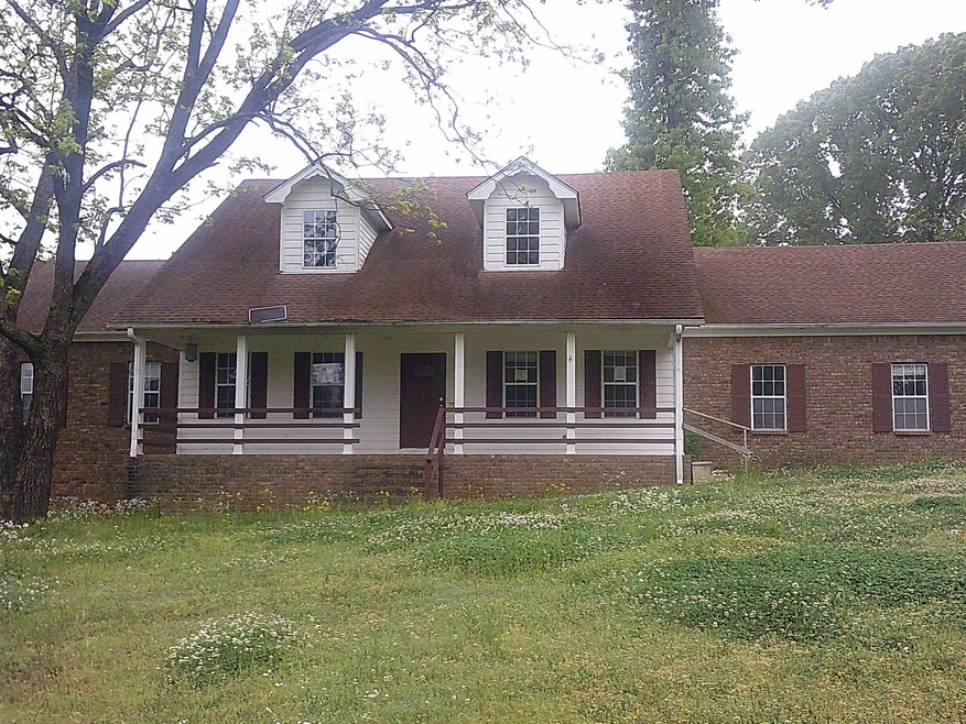 Cape cod home with a front lawn and covered porch