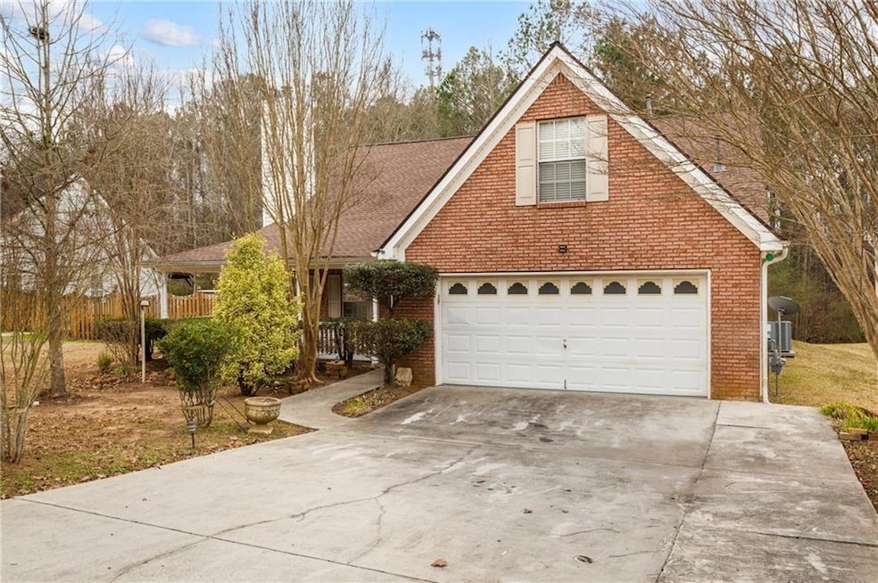 Traditional-style home featuring concrete driveway, brick siding, and a shingled roof