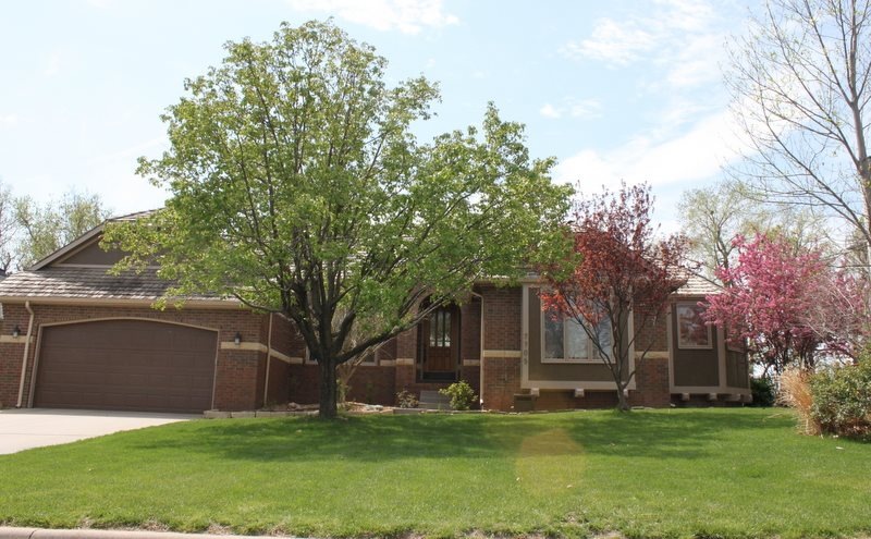 Brick with Stone Ribbon and mature landscaping add