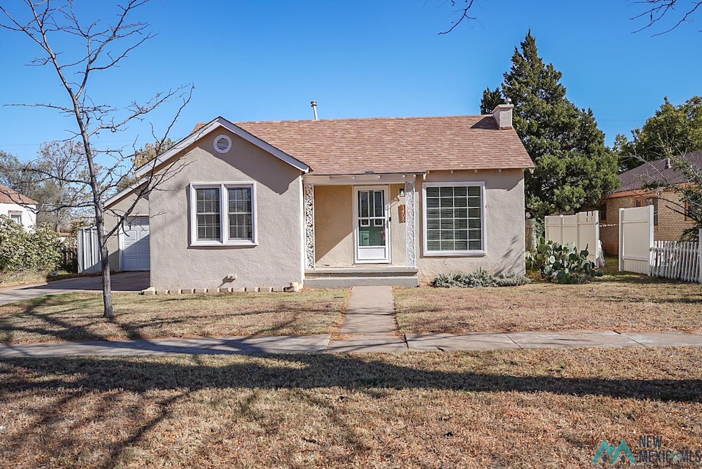 Bungalow with stucco siding, a shingled roof, and a chimney