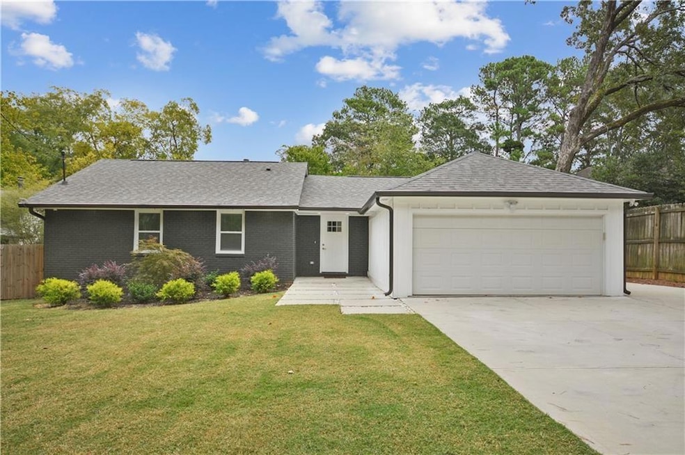 Renovated Ranch-style home featuring driveway, a garage, fence, and a front yard