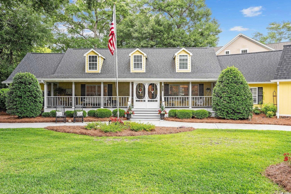 Cape cod-style house featuring a front yard, a por