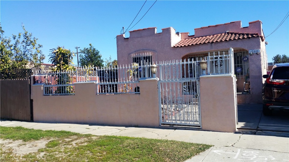 Main entrance gated, long driveway to garage.