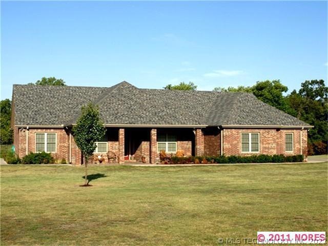 Front view of custom home on a scenic 5 acre lot with pond.