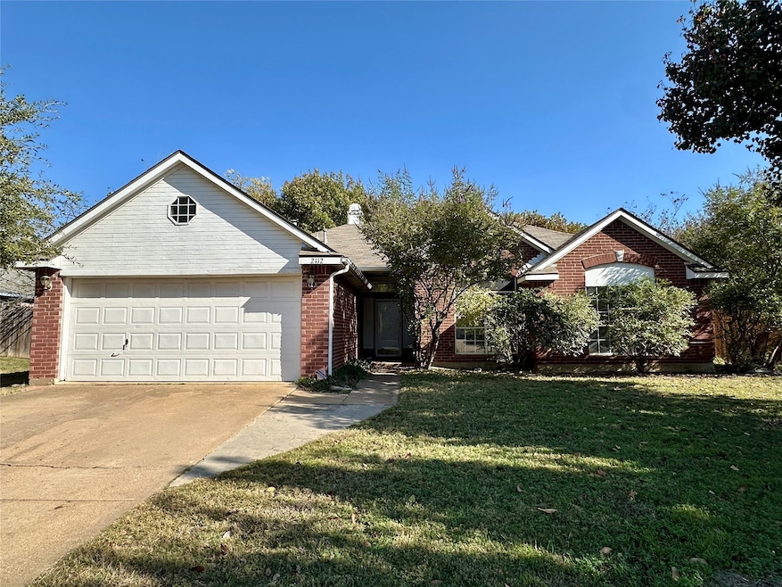 Single story home featuring driveway, a front yard, brick siding, and a garage