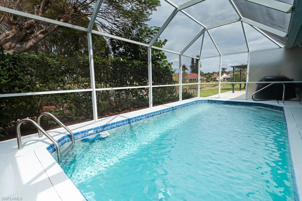 View of swimming pool with area for grilling and glass enclosure