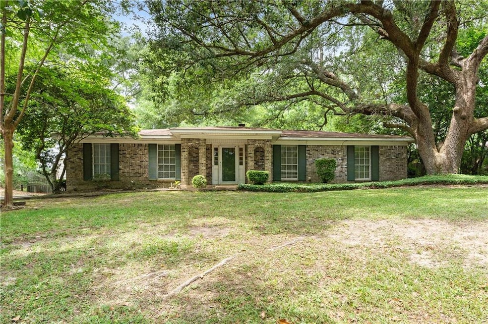 Single story home featuring a front yard and brick