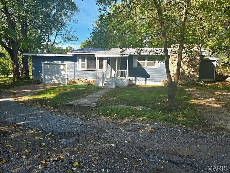 View of front of house with driveway, a front yard, and a garage